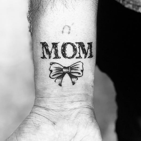 Bold letter mom tattoo with a beautiful bow