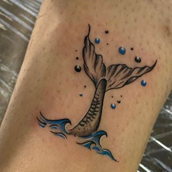 Small customize whale tattoo with ocean wave