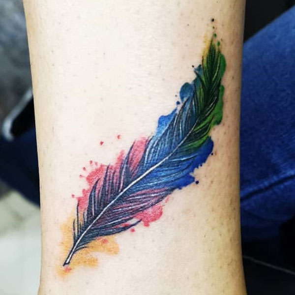Small colorful feather tattoo on hand