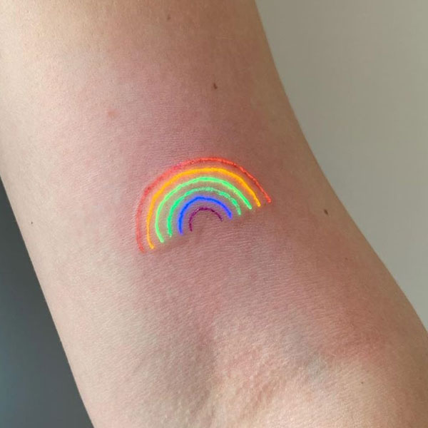 Small Glow ink rainbow tattoo