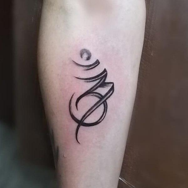 Black brush stroke Om design tattoo for the arm