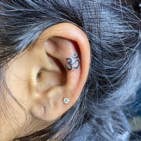 Tiny om sign ear tattoo design idea