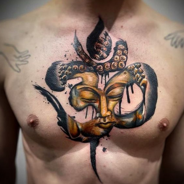 A stunning combination of om and buddha tattoo on the chest