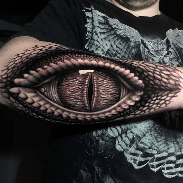Dazzling Aligator eye tattoo over the arm