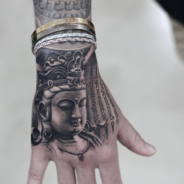 Pretty Buddha face tattoo on the hand