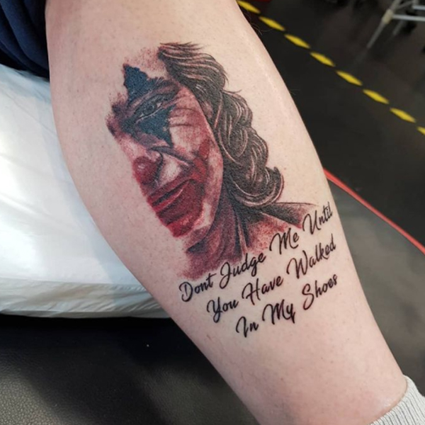 Stunning half-face joker and quote tattoo 