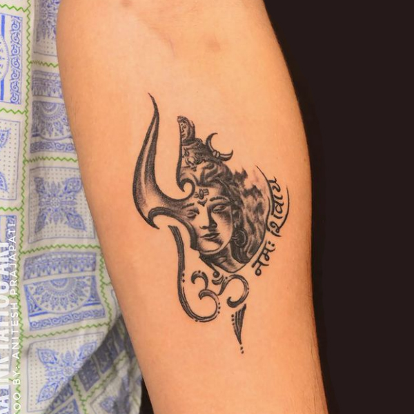 Creative half shiva face and trishul with mantra tattoo