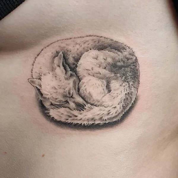 A cute Sleeping Wolf Deisgn tattoo for chest