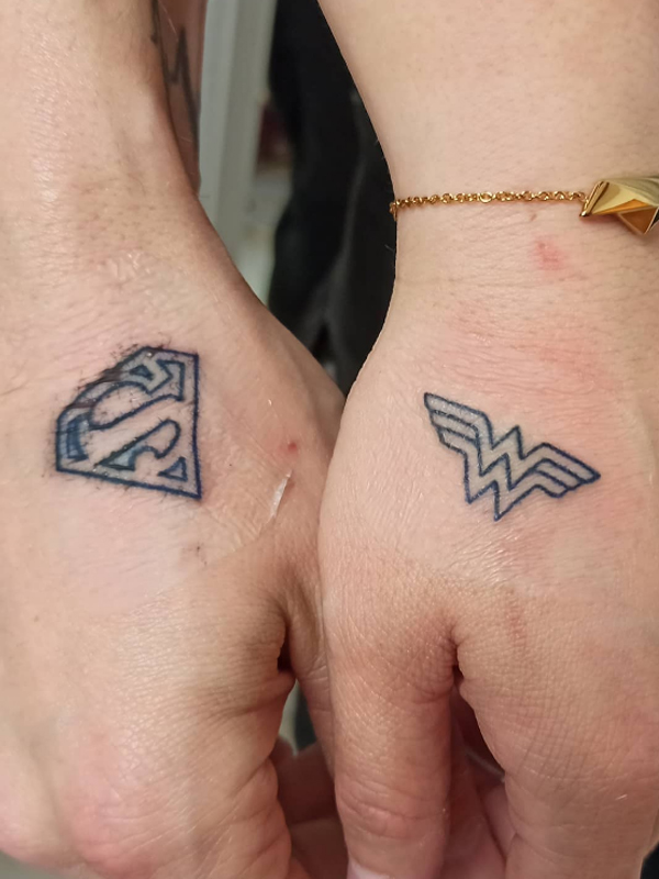 Simple black Superman and wonder women logo matching couple tattoo design
