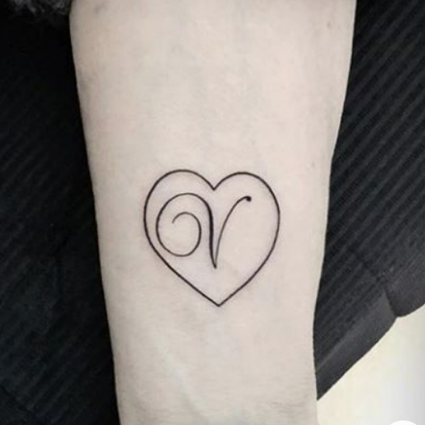 Fine line V-letter with heart symbol tattoo