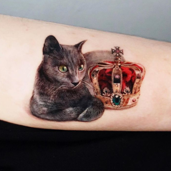 The elegant golden crown and cat tattoo design