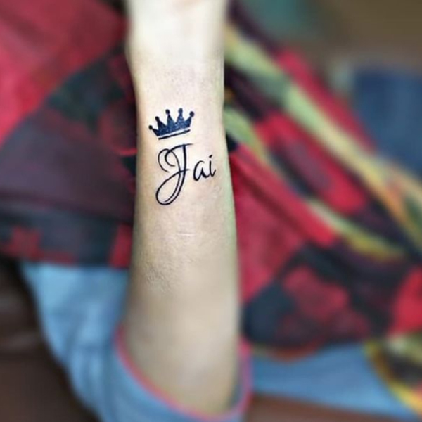 Small black crown and name tattoo 