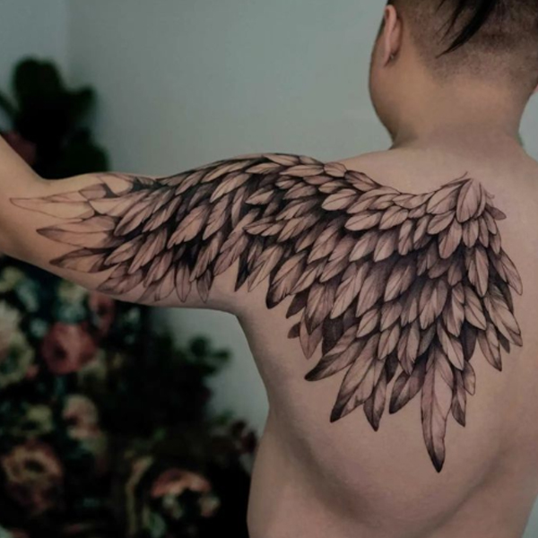 A large wing on the back shoulder to the arm tattoo design