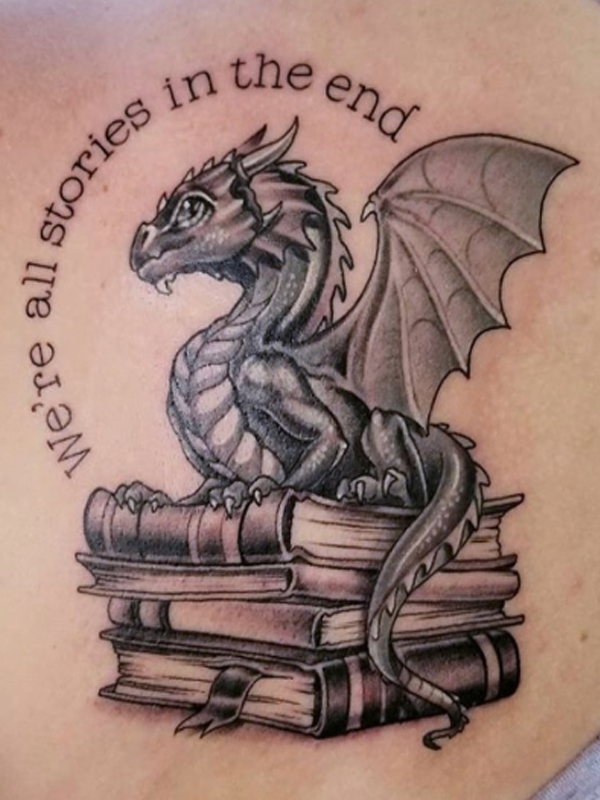 A black and grey dragon and quote tattoo design