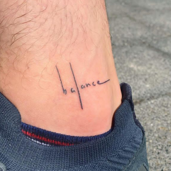 Line art balance word tattoo on the ankle